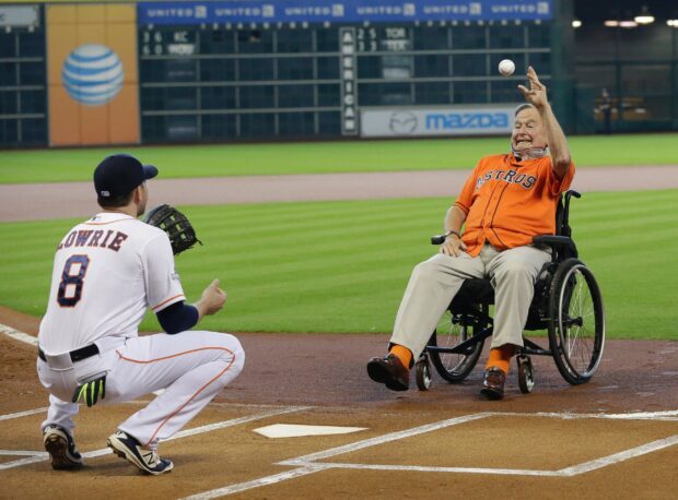 Houston Astros player Lowrie catching ball from man in wheelchair on baseball field