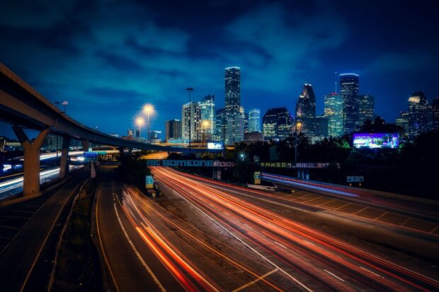 Houston Texas cityscape at night with highway light trails and skyscrapers
