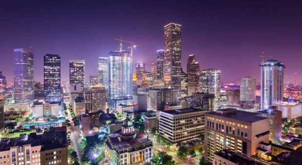 Downtown Houston Texas cityscape illuminated at night with skyscrapers and streets visible