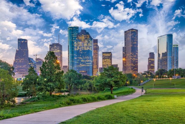 A scenic view of Houston Texas with lush green park and city skyline at dusk
