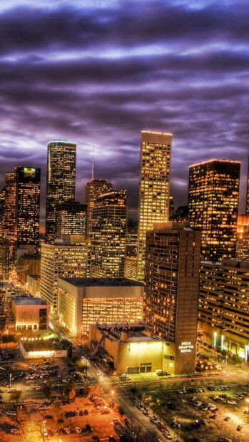 Houston city skyline with tall buildings under a dramatic cloudy sky at dusk
