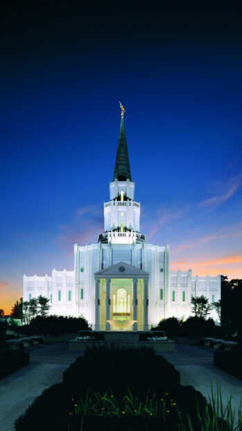 The Houston temple stands illuminated against the twilight sky in Houston Texas