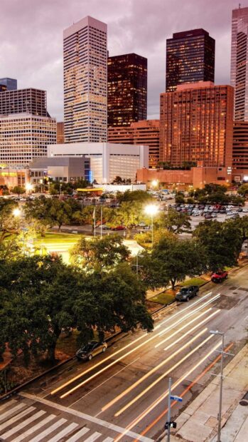 Evening cityscape of Houston Texas with illuminated buildings and busy streets