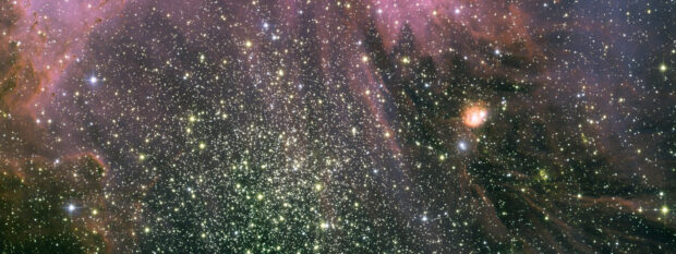 A star cluster captured by Hubble displaying a dense collection of stars and cosmic dust in space