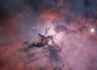 A colorful nebula with bright stars and cosmic clouds captured by Hubble