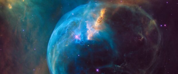 A stunning nebula captured by Hubble showing vibrant blues and glowing stars in deep space