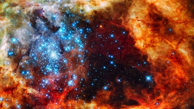 Bright cluster of stars in a colorful nebula captured by Hubble