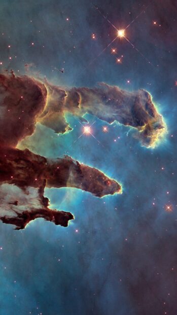 Pillars of gas and dust in space captured by Hubble showing bright stars and nebula clouds