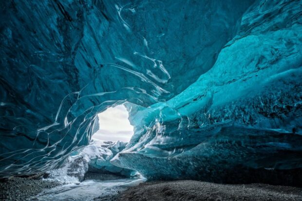 A stunning view of blue ice cave with a natural arch showcasing ice cave formations