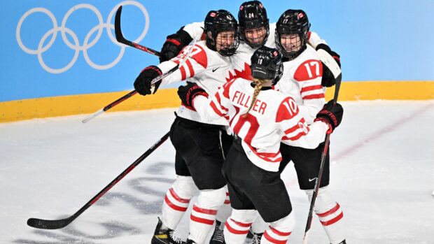 Female ice hockey players celebrating a goal in a team match