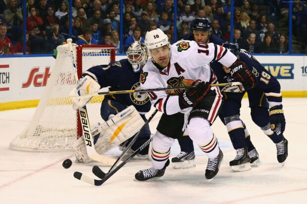 Ice hockey players competing fiercely near the goal crease in an intense hockey match