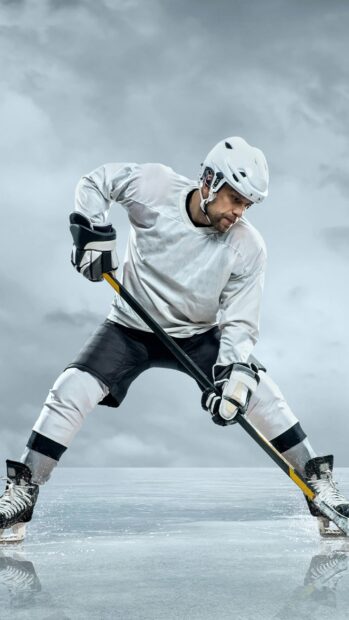 A skilled ice hockey player in white gear controlling the puck on the ice rink