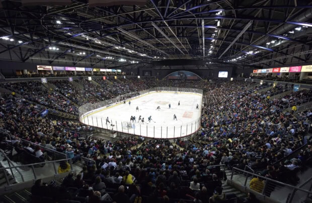 A crowded ice hockey arena with players competing on the ice during a live game