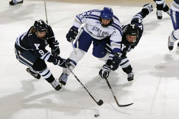 Ice hockey players competing intensely for the puck on the ice rink during a fast paced match