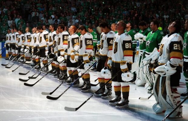 Ice hockey players standing in a line on the ice rink before the game starts