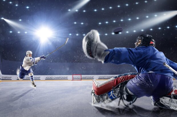 Ice hockey players competing in an intense game on ice rink with dramatic lighting