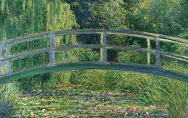 A serene impressionist scene of a curved footbridge over a pond surrounded by greenery