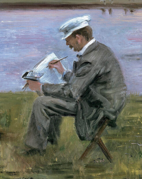 A man wearing a hat painting outdoors in an impressionist style on grass