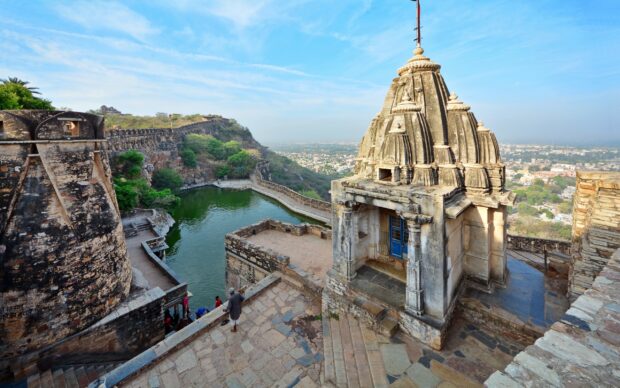 Ancient India architecture overlooking a water reservoir and green hills in India