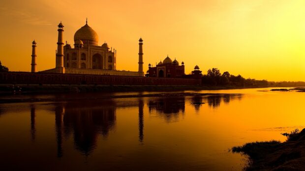 The sunset view of India reflects on calm river water near Taj Mahal