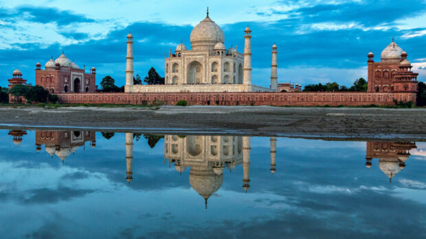 The Taj Mahal reflected in water on a clear sky day in India