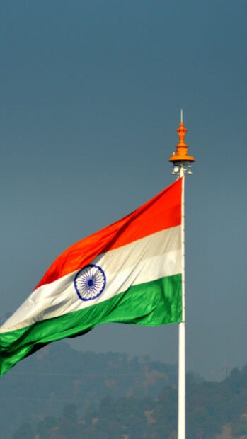 Indian flag fluttering high against a clear blue sky