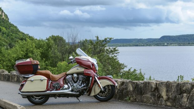 Classic Indian bike parked by scenic lake and green trees