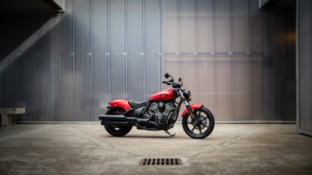 Red Indian bike parked in front of a modern translucent wall on concrete floor