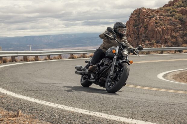 Rider on an Indian bike leaning into a curve on a mountain road
