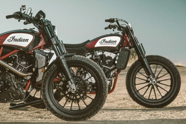 Two Indian Scout bikes parked on a sandy surface with detailed carbon fiber parts and tires visible