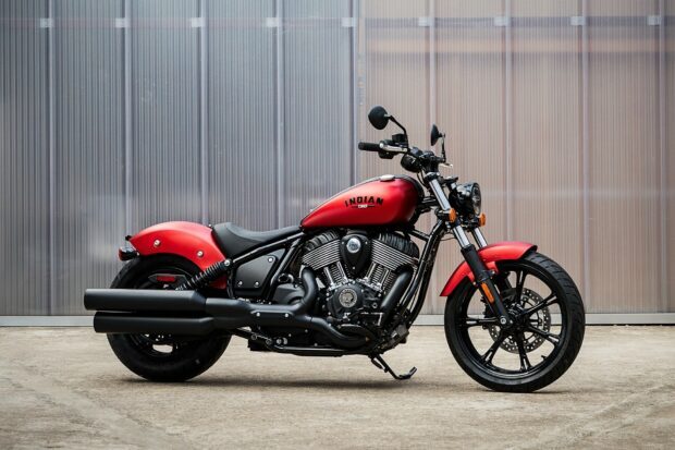 Red Indian Chief motorcycle parked on concrete floor against a translucent wall
