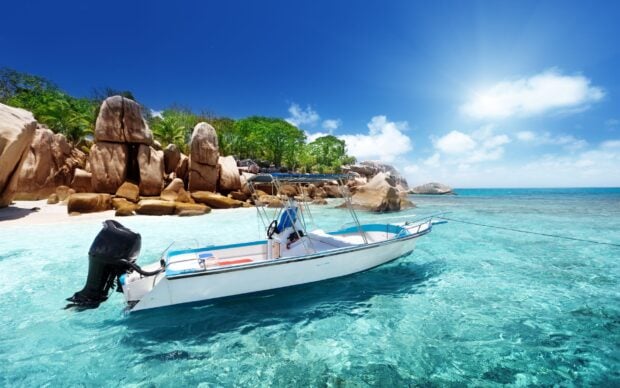 Clear water and rocky shore with a boat in the Indian Ocean
