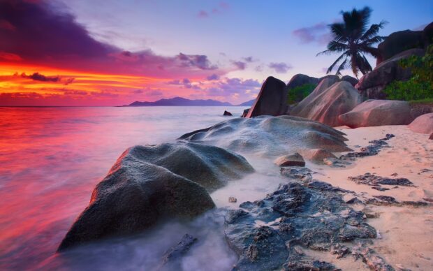 Smooth rock formations along the Indian Ocean coastline during a colorful sunset