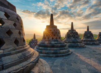 The ancient Borobudur structure with stone stupas at sunrise in Indonesia