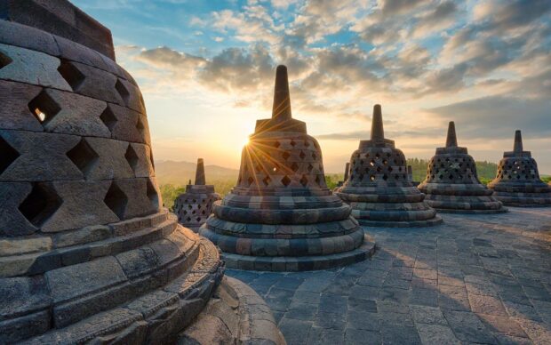 The ancient Borobudur structure with stone stupas at sunrise in Indonesia