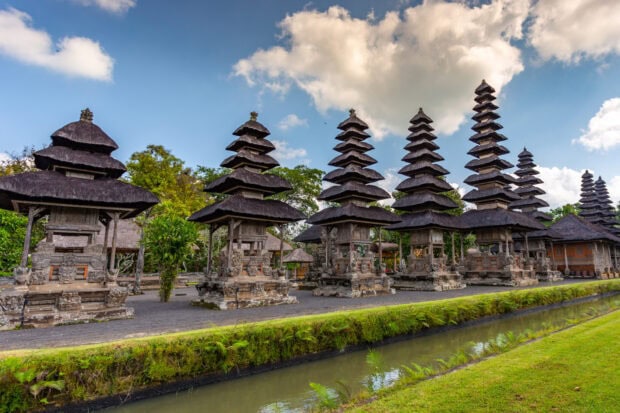Traditional Indonesia temple structures with tiered roofs under a cloudy sky