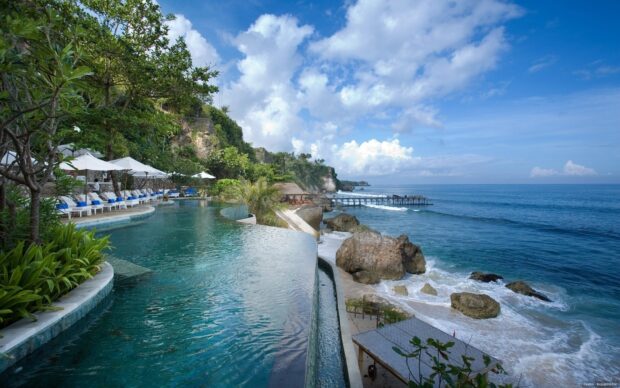 Infinity pool overlooking the ocean and rocky coastline on an Indonesia cliffside