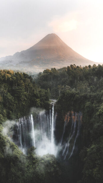 Majestic volcano surrounded by lush forest and waterfall in Indonesia landscape