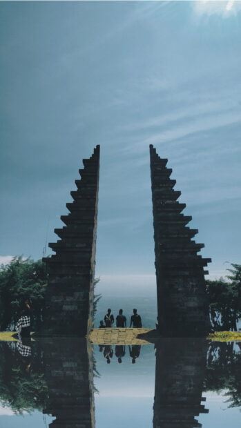 Traditional Indonesian gate with people standing near a scenic viewpoint in Indonesia