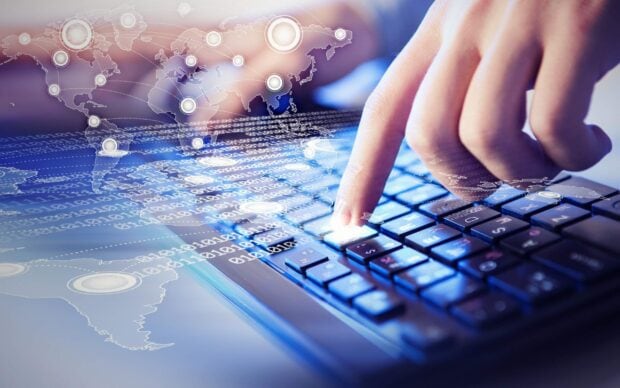 Digital innovation concept showing global connectivity with a finger pressing a key on a keyboard