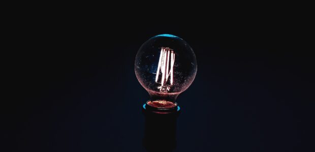 A close up of innovation showing a glowing filament inside a light bulb