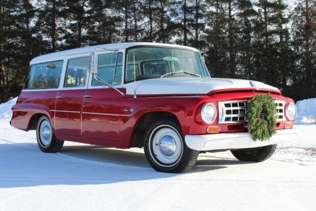 Classic International Harvester vehicle with a wreath on the front grille parked on snowy ground