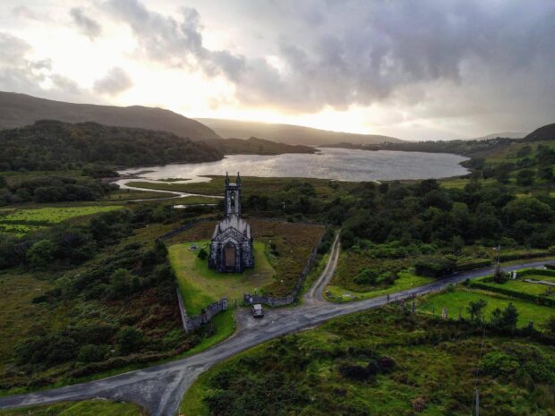 Old church ruins in Irish countryside near a lake and green fields