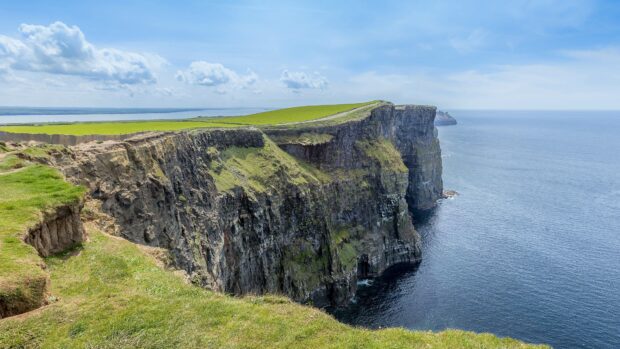 Steep cliffs and green fields in the Irish countryside landscape