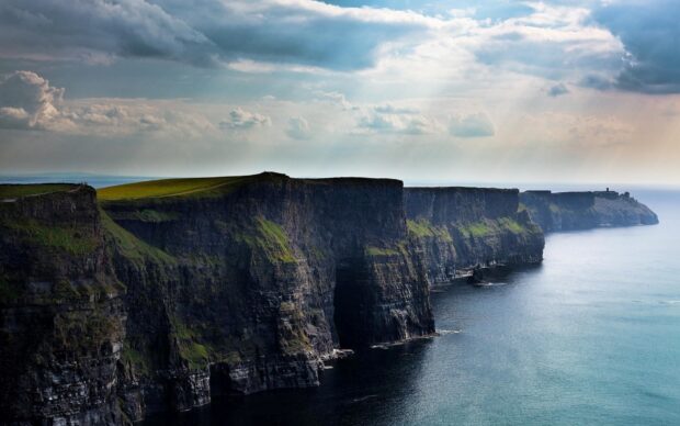 Dramatic cliffs along the Irish countryside under a cloudy sky overlooking the ocean