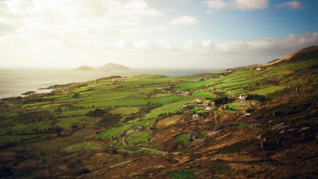 Rolling hills of Irish countryside with green fields and scattered houses