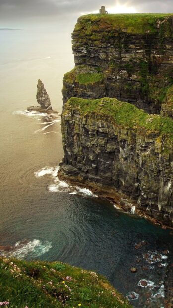Dramatic Irish coastline with steep cliffs and lush green fields above the ocean shore