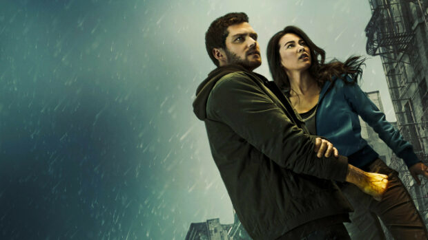The Iron Fist hero standing protectively with a woman in a rainy urban setting