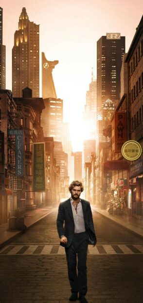 Iron Fist standing confidently in a city street with sunlight glowing behind him