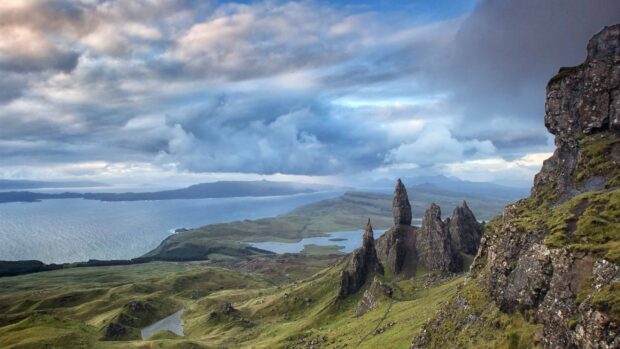 Dramatic Isle Of Skye stunning rock formations and green hills under cloudy sky